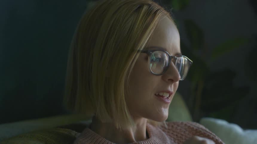 A woman is sitting and talking at home