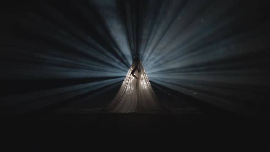A woman is wearing a dress and standing on a stage