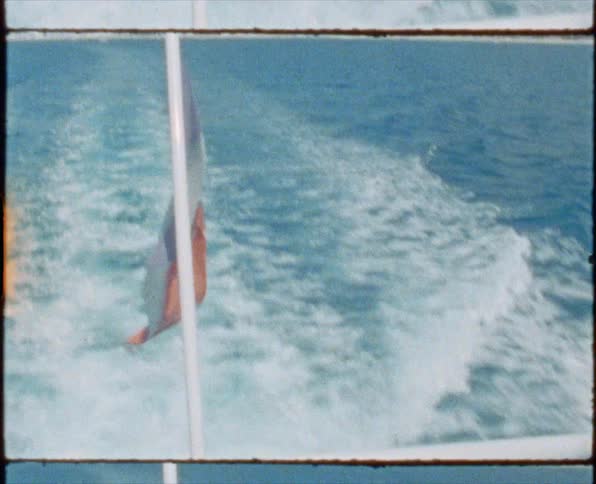 A boat is sailing in the water with a flag on the back