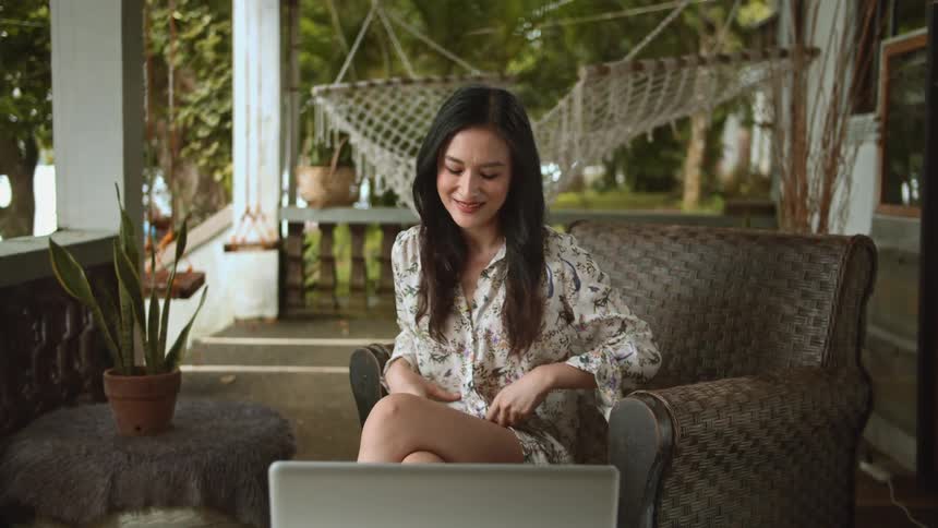 Woman proudly displays her blouse while chatting on her laptop