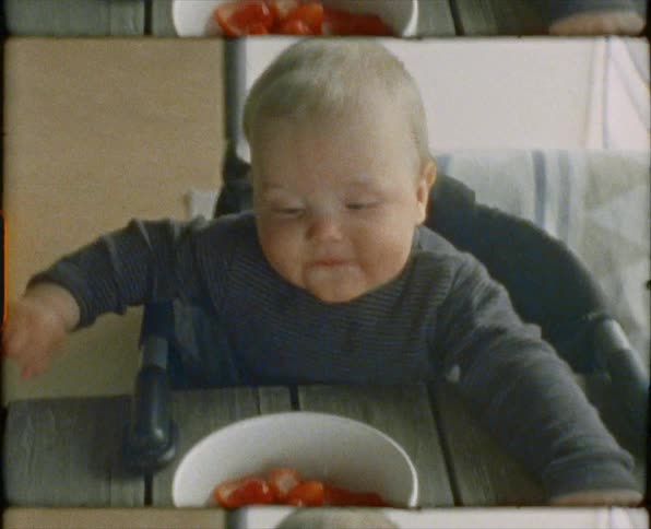 A child sitting at a table with a bowl of food in front of them