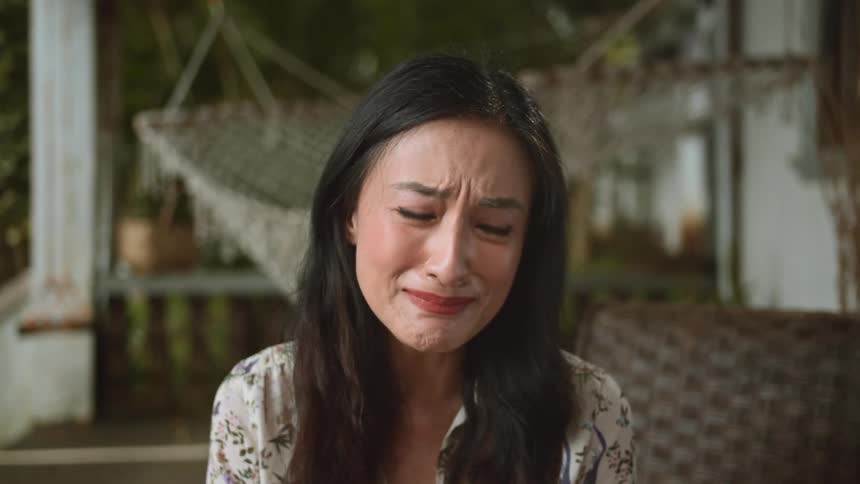 A woman nods her head while crying as she learns of something upsetting
