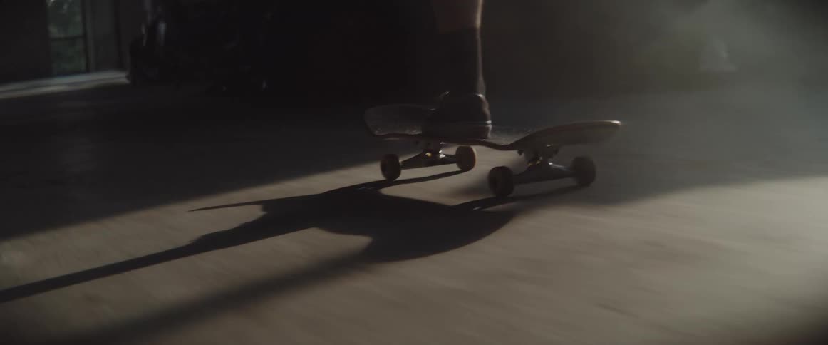 A person skateboards through a building with very dirty floors