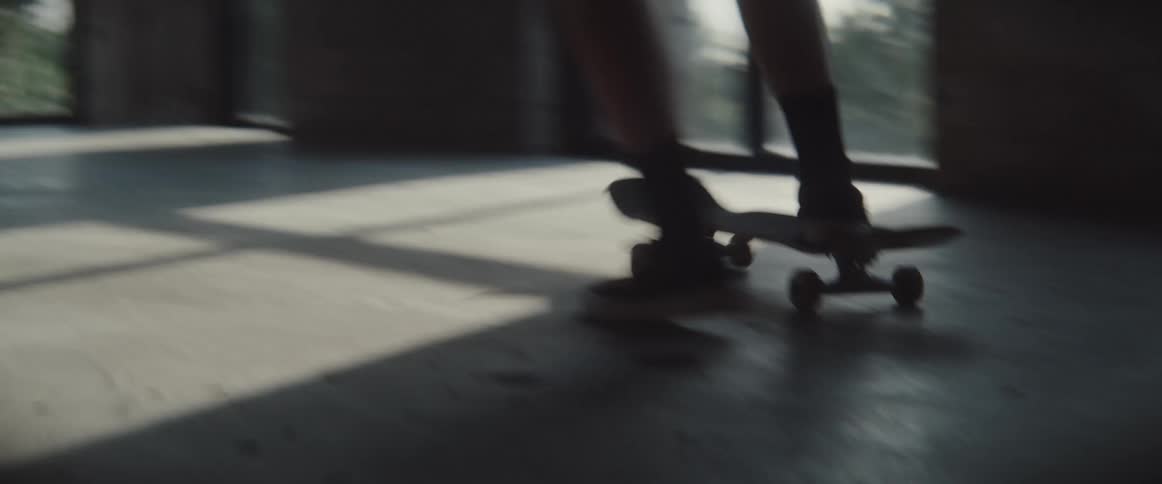 A person rides a skateboard in an empty indoor space