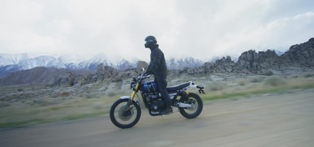 A man is riding a motorycle in a rural area