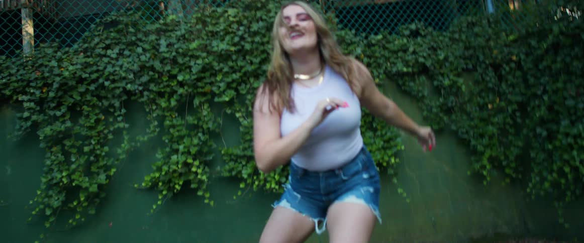 A teenage girl dances in a park