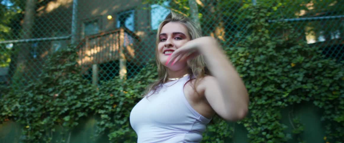 A woman is dancing outdoors during the day in spring