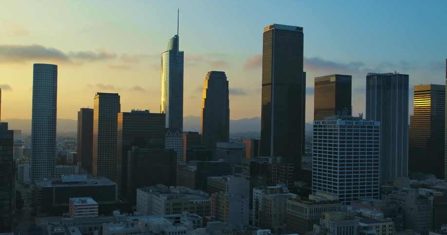 A city skyline with buildings and skyscrapers with the sky and clouds in the background