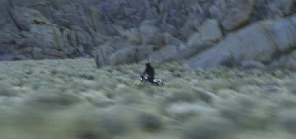 A person driving a motorbike across a field