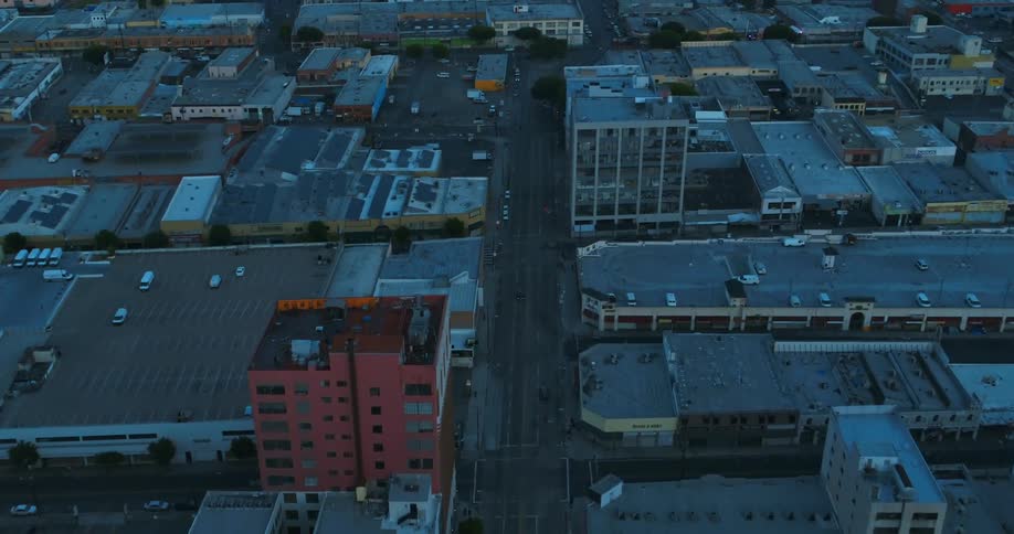 An aerial view of cars driving down a street next to buildings