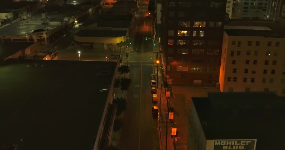 Aerial view of city streets with intersection and buildings at night