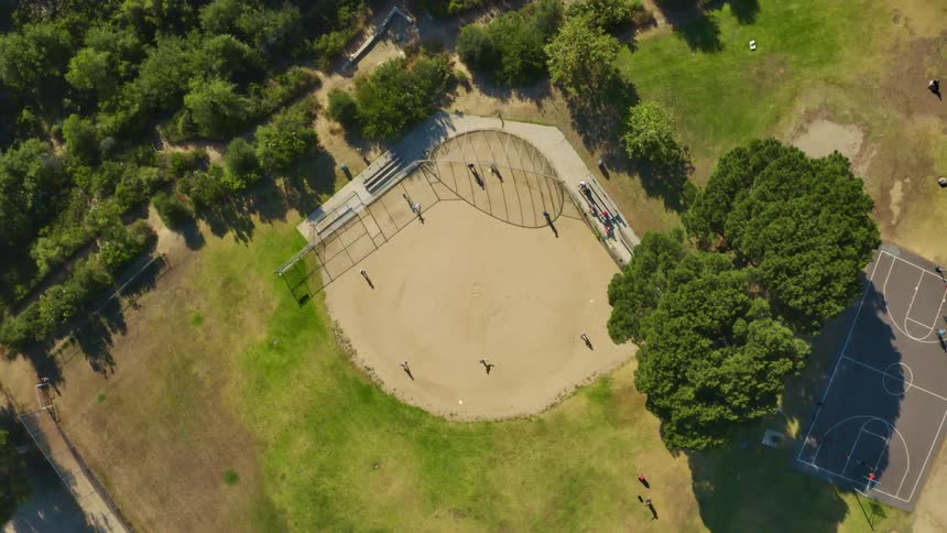 People playing in a park surrounded by grass and trees