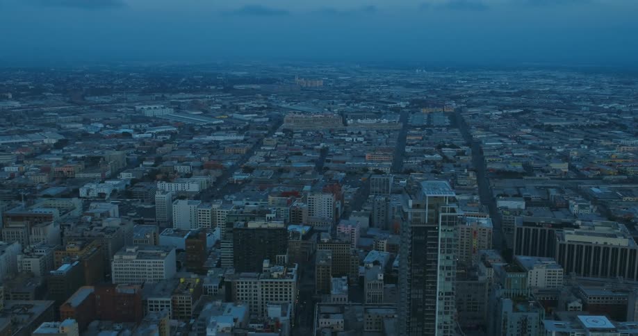 Aerial view of city streets with houses and buildings at dusk