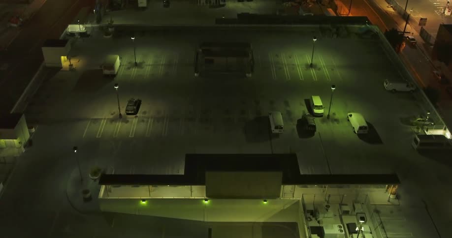 A view of a semi lit parking lot structure near a road