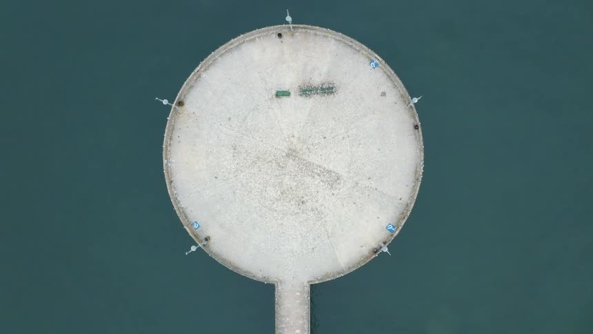 A concrete structure in the water is shown with an aerial view