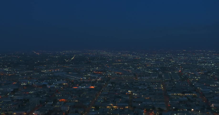 City lights stretch to the misty blue horizon at night