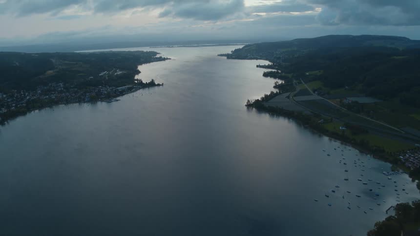 A river with a small town on its shore under a cloudy daytime sky