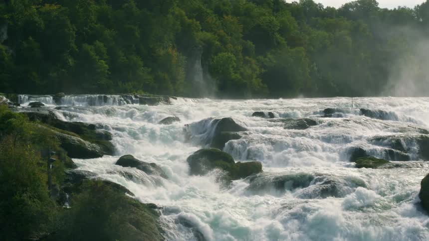 A river with water and rocks with trees the sky and clouds in the background
