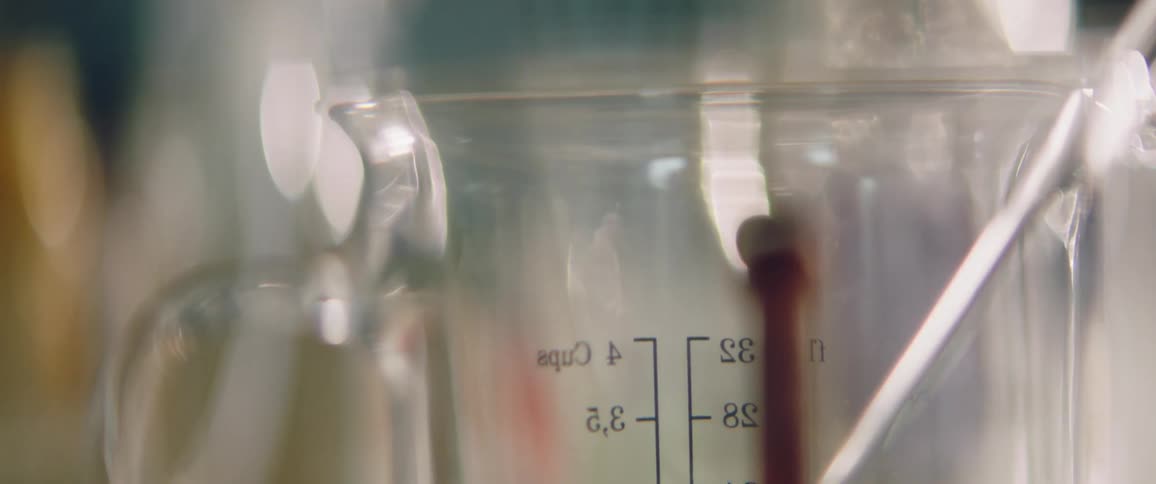 A glass container has lines on it for measuring various volumes of liquid