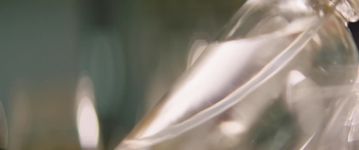 A glass bottle has liquid in it the sloshes around as the container is tilted and lifted