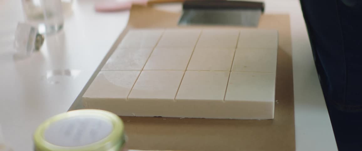 A woman removes bar of soap from a mold