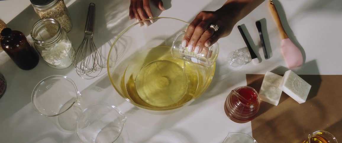 A woman pouring a liquid into a bowl on a table