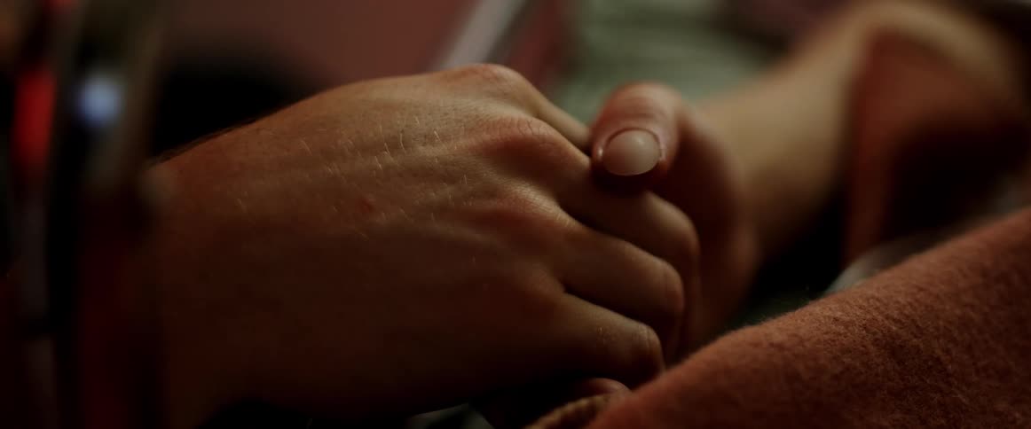 A man and a woman in a room holding hands
