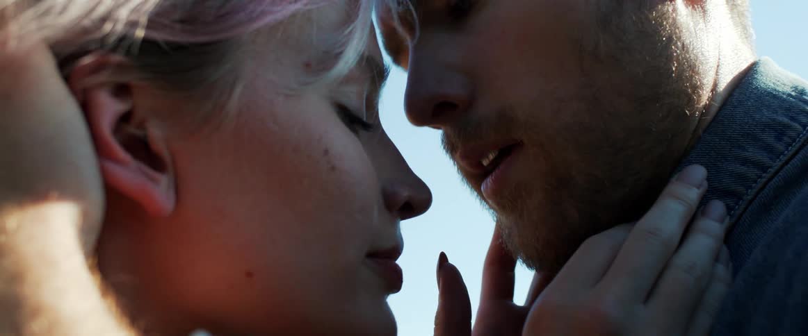 A boyfriend and girlfriend kissing outdoors