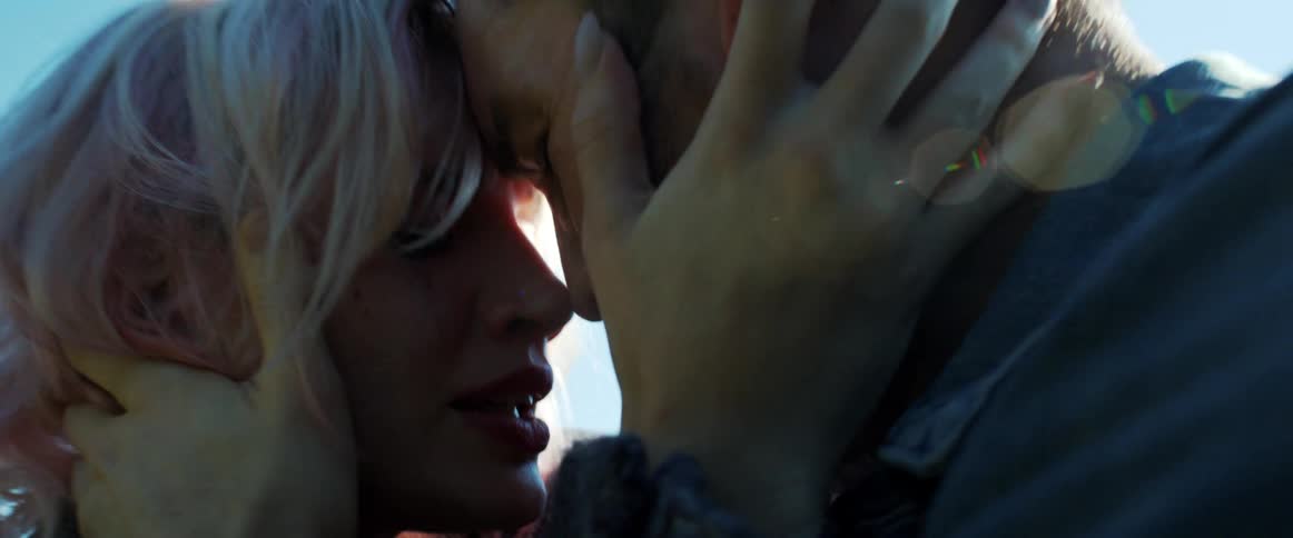 A man and woman embracing with their foreheads touching outside
