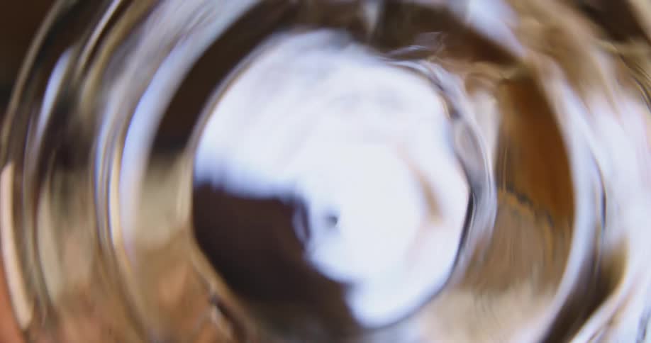 A person swirling alcohol in a glass