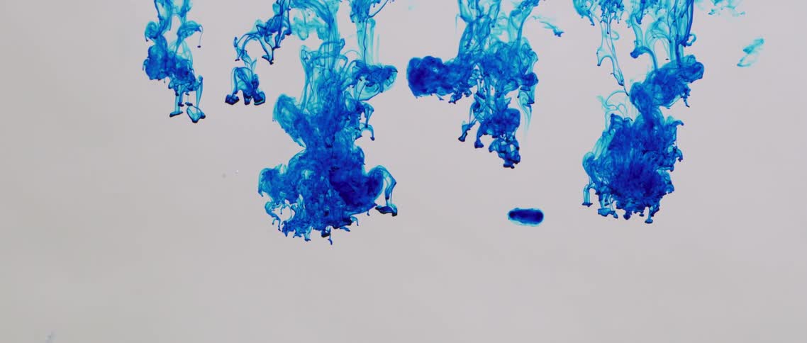A view of blue dye dropping into water