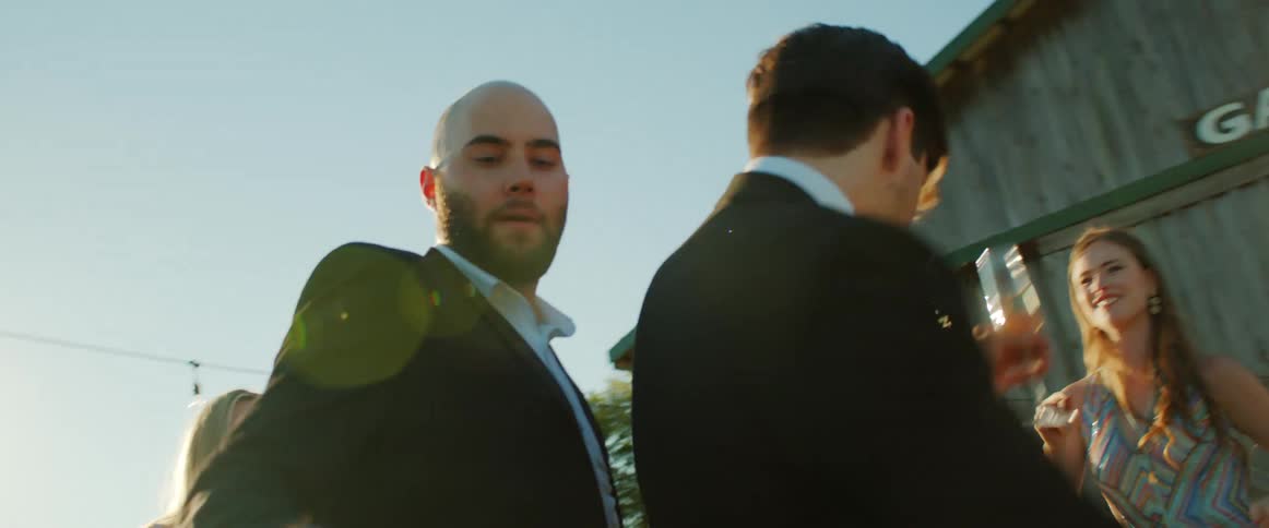 A group of people dancing outside at a wedding in the daytime