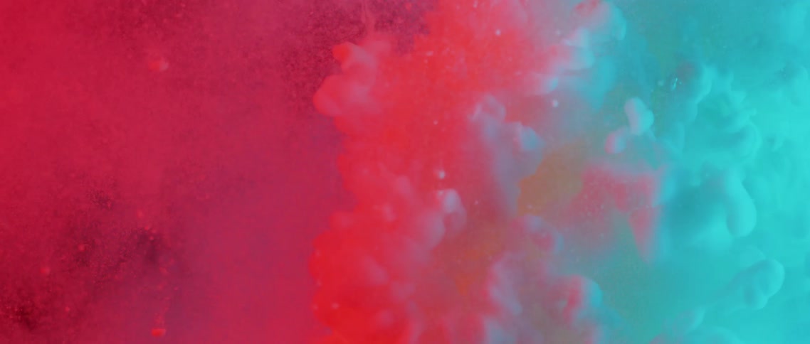 Tablets float down in colorful liquid before a burst of dye expands