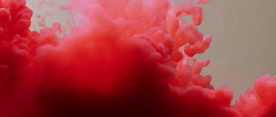 A red powder sinks in liquid and explodes upward