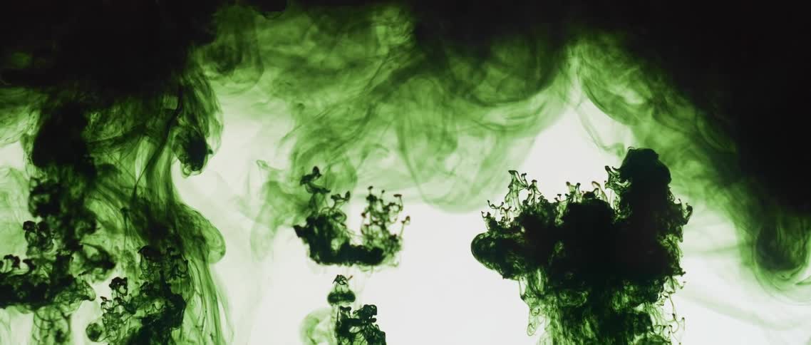 A dark green liquid that is mixing into clear liquid appears to move in reverse