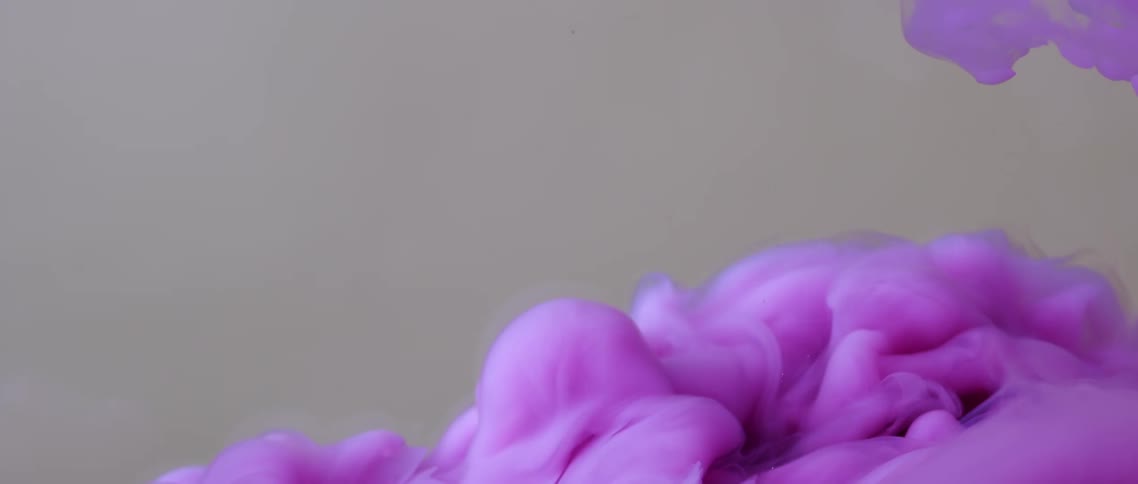 Cloudy light purple smoke moving upwards on a grey backdrop