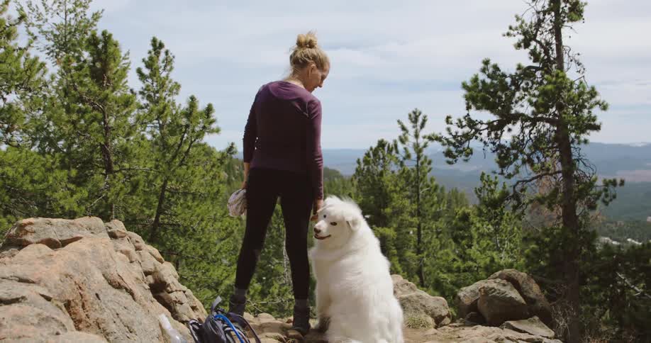 A woman standing outdoors with her dog