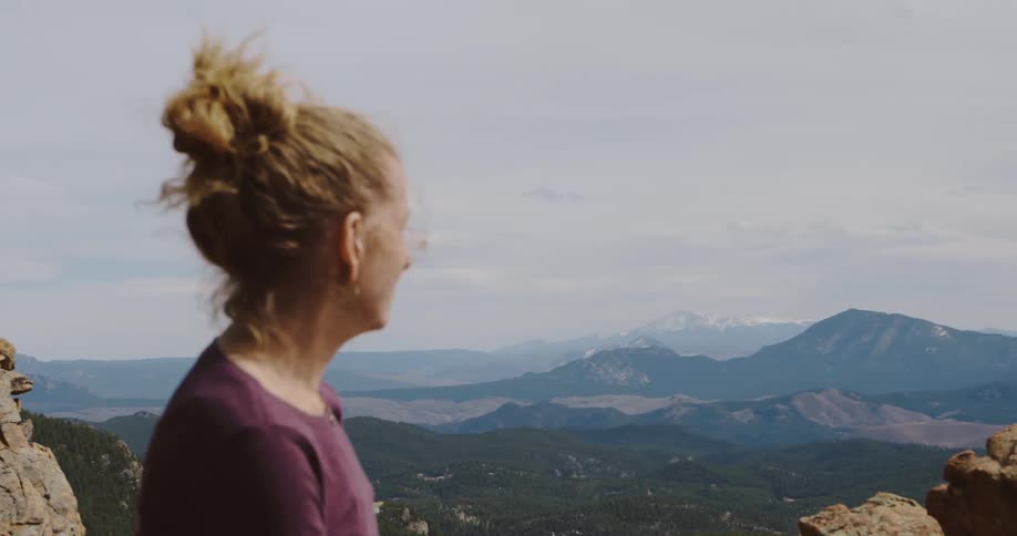 A hiker takes in the view atop the summit of a canyon