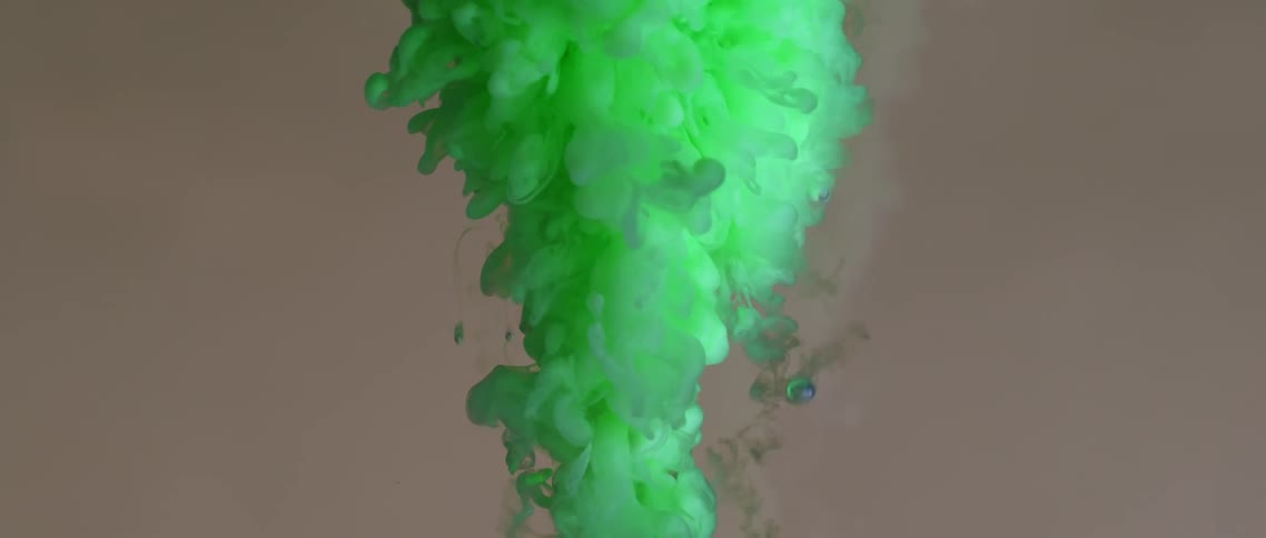 A green cloud of powder dye bursts upwards
