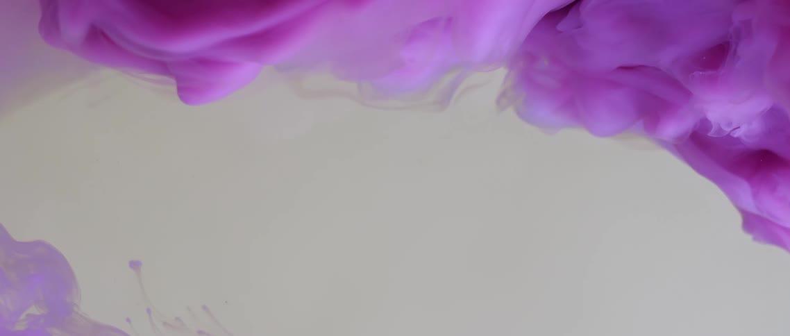 Bright violet magenta ink flowing and swirling on a tank of clear water