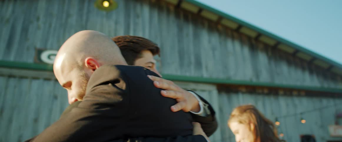 Two men hugging each other in suits
