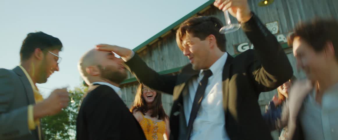 A group of people dancing around outside at a party