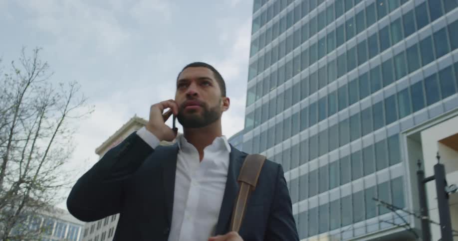 A business man walks and talks on the phone
