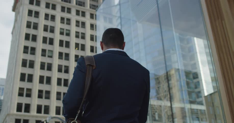 A man stands in front of a tall building