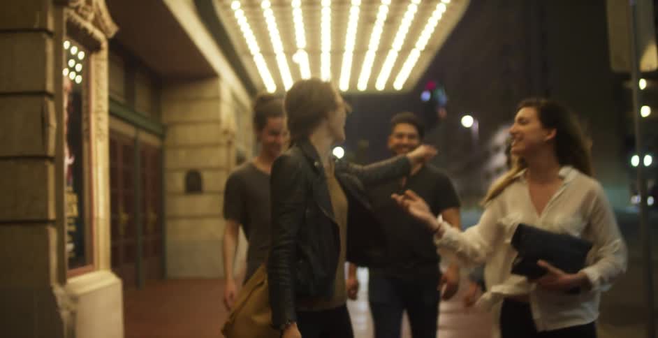 A group of people walk outside a theater