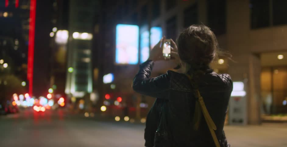 A group of people out taking pictures at night