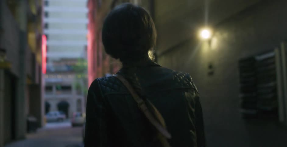 Woman walks down a city alley