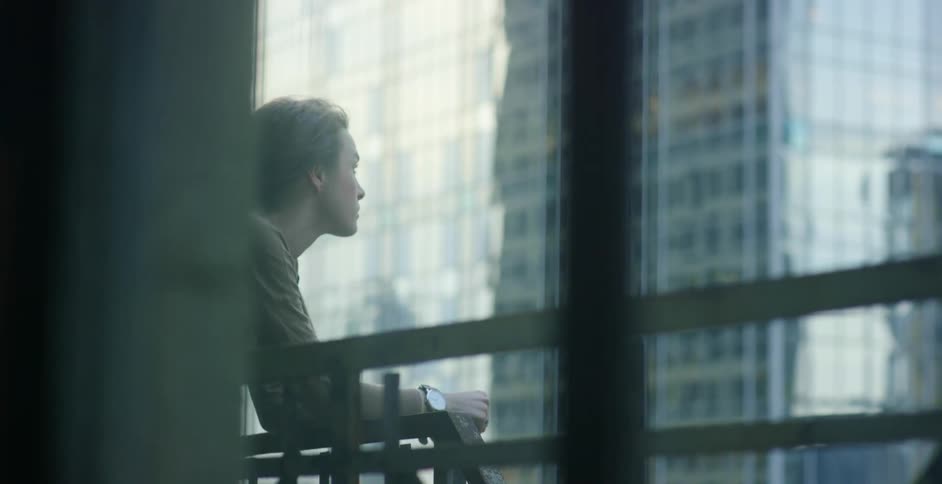 A woman overlooks a balcony in the city