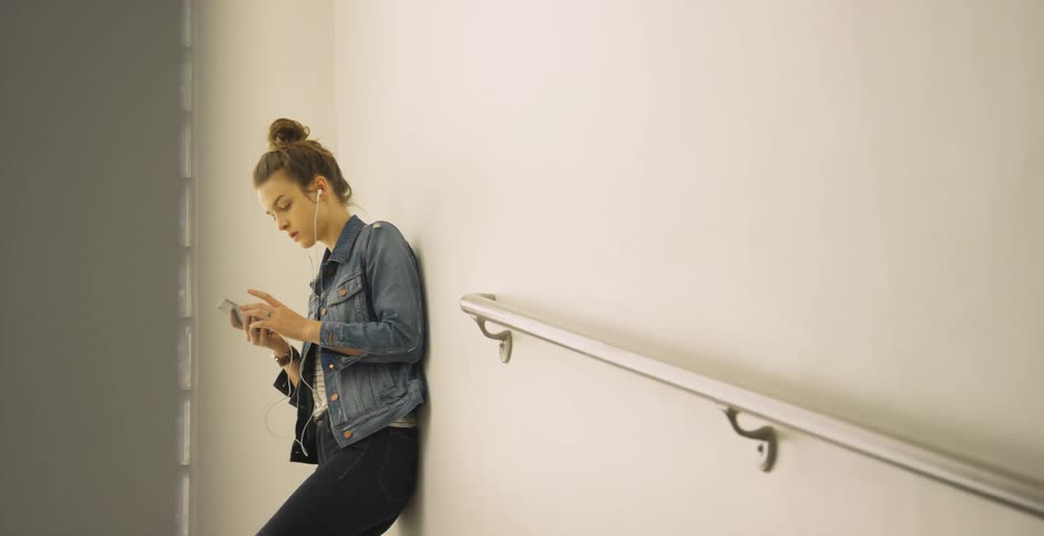 Woman standing in a hallway listening to her phone