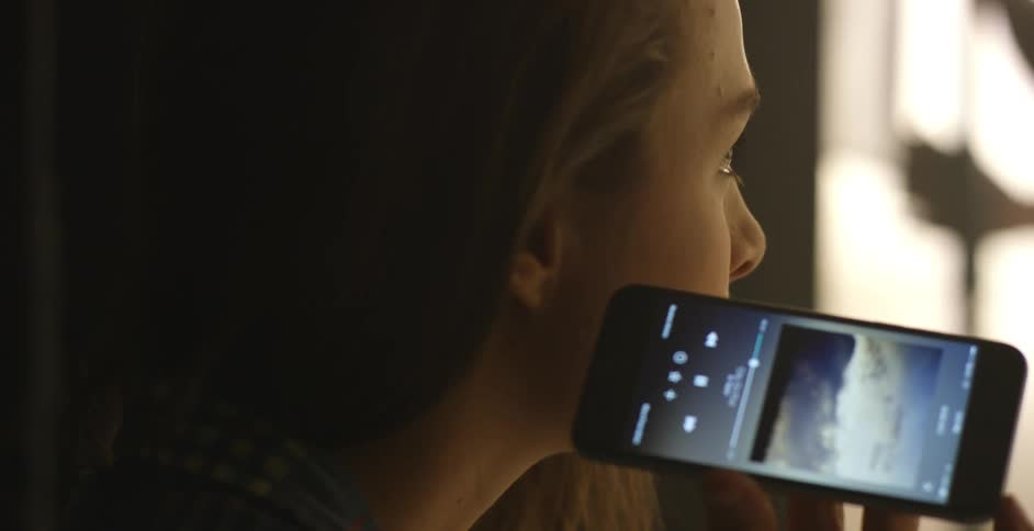 A girl listens to music on a smartphone